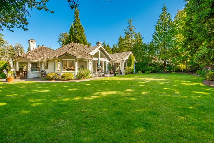 Stack of books next to pencils in a holder and a camera.