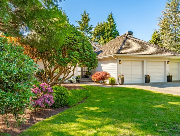Landscaped front yard with flowering bushes.