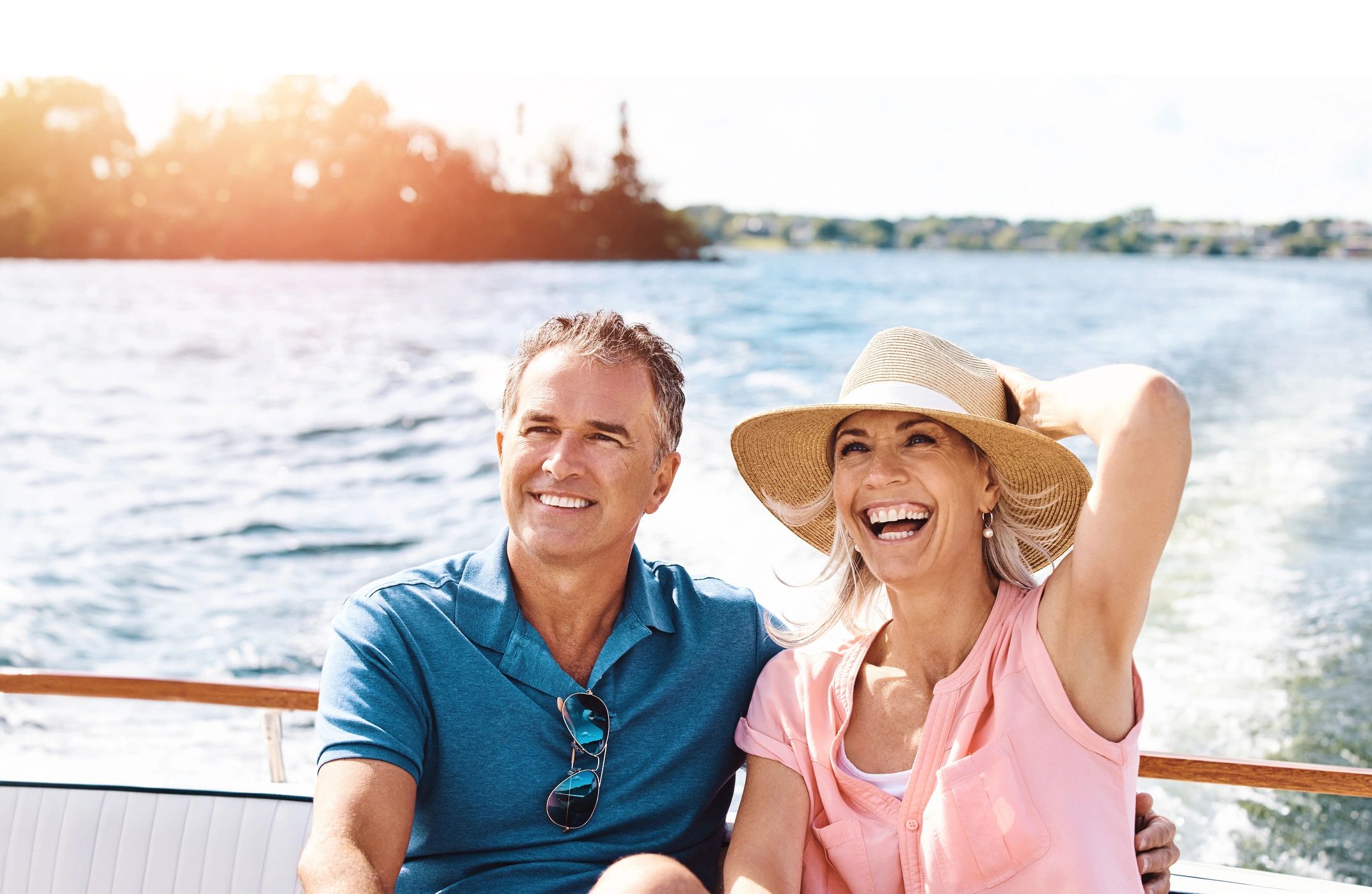 Happy couple enjoying a boat ride on a sunny day.