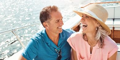 Smiling couple enjoying a boat ride on a sunny day.