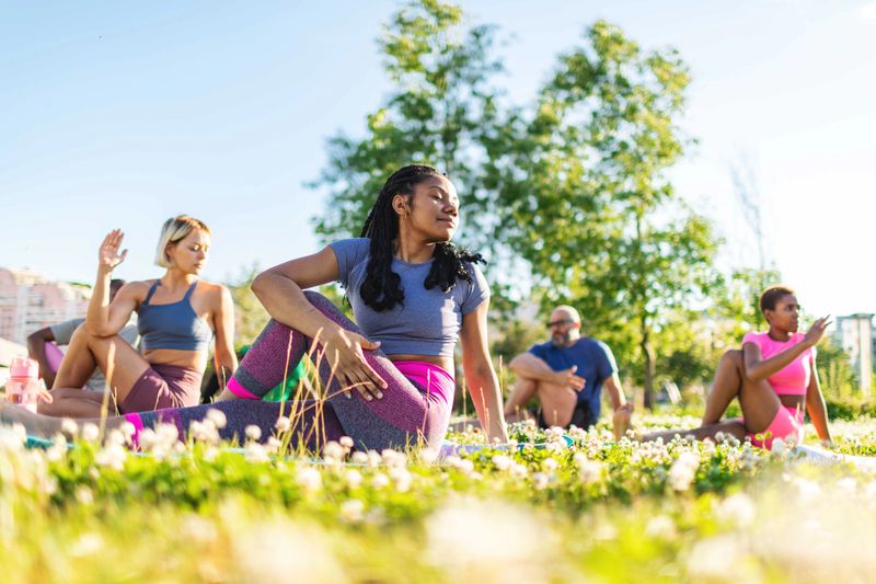 Group of diverse individuals exercising outdoors in a fitness class, showcasing dedication and teamwork.