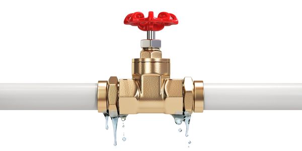 Leaking brass valve with dripping water on white background.