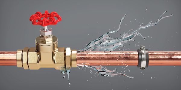 Water leaking from a damaged copper pipe with a valve.