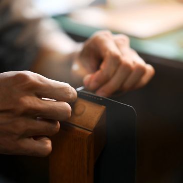 Close-up of hands crafting leather with precision.