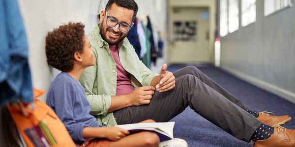 Foster father and child sitting in a hallway