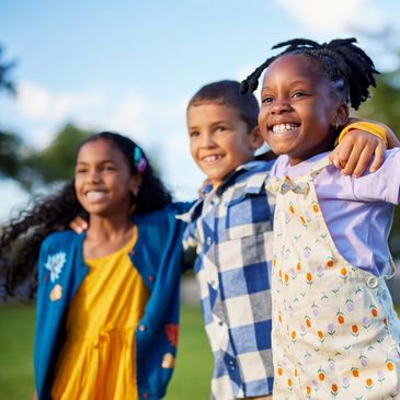 A group of children outdoors smiling.
