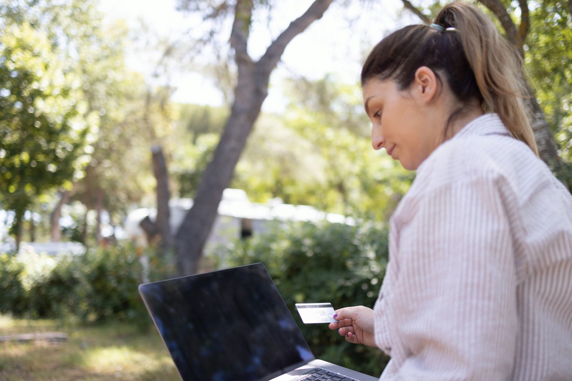 Woman processing credit card on a computer.