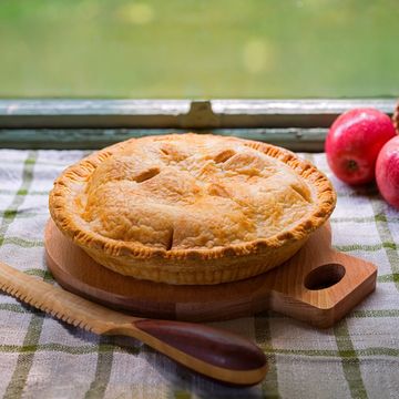 Freshly baked apple pie on a wooden board.