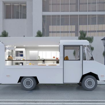 White food truck with a modern kitchen setup inside, parked on a city street.