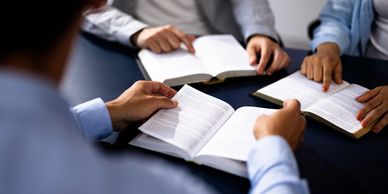 People reading and discussing books at a table.