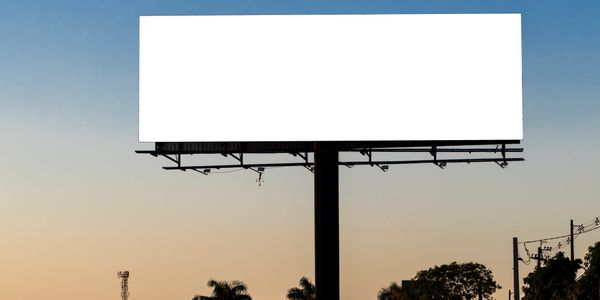 A large blank billboard against a clear evening sky.