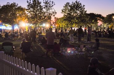 People gathering outdoors in the evening for an event.