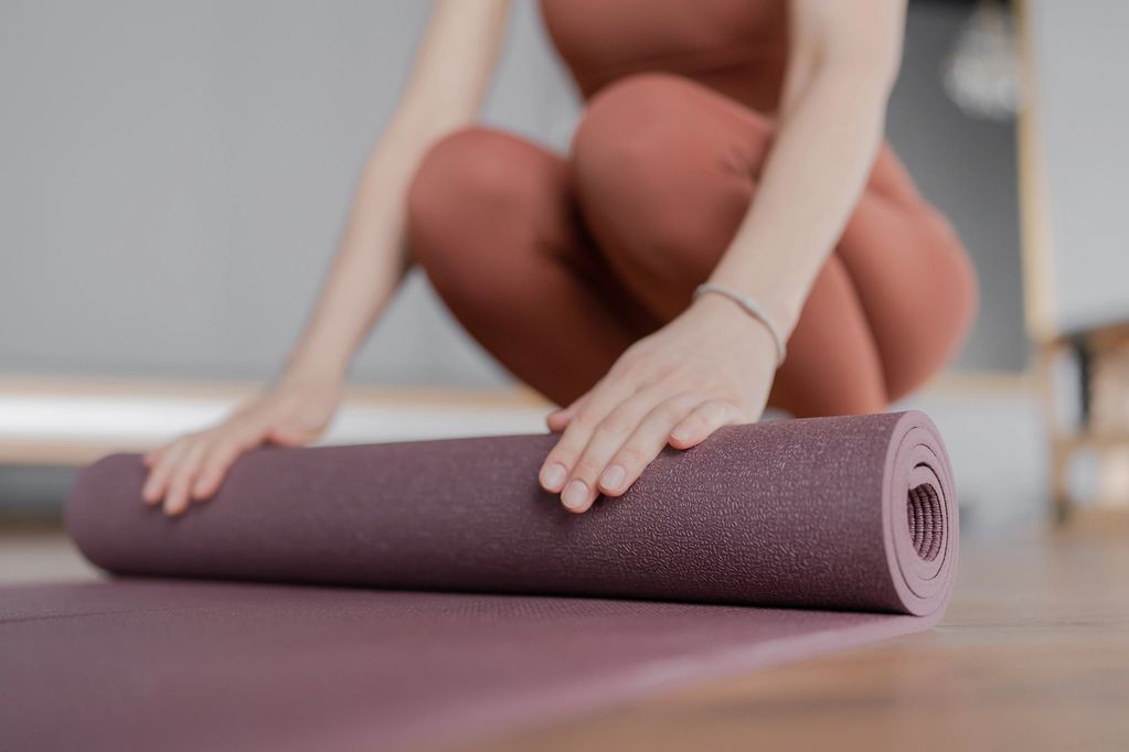 Somatic movement in Lauderdale-by-the-Sea – woman rolling out mat for nervous system work.