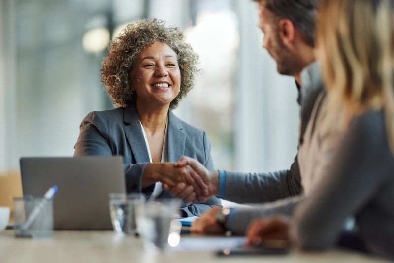 Happy multiracial businesswoman came to an agreement with her colleague during a meeting in the office.