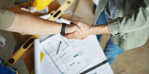 Handshake over architectural blueprints.