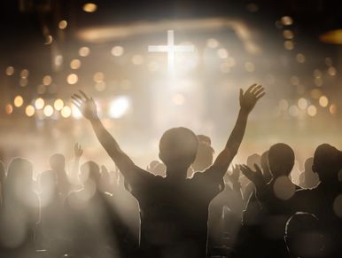 Person worshiping with raised hands in a church.