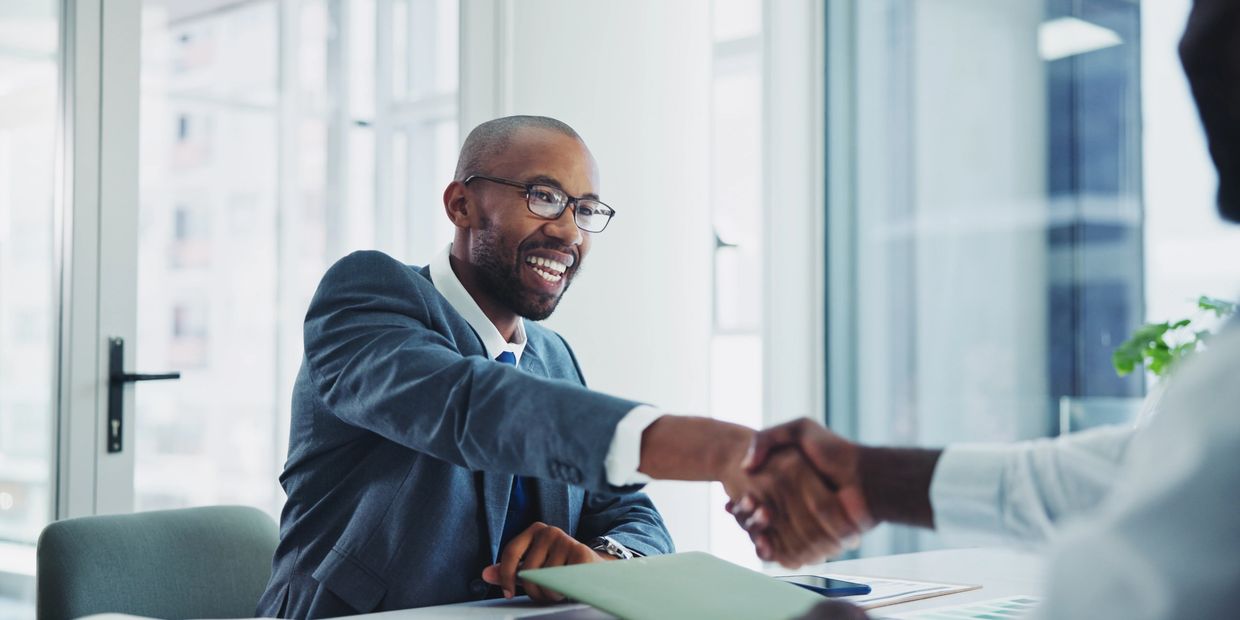 Businessmen shaking hands in a modern office setting.