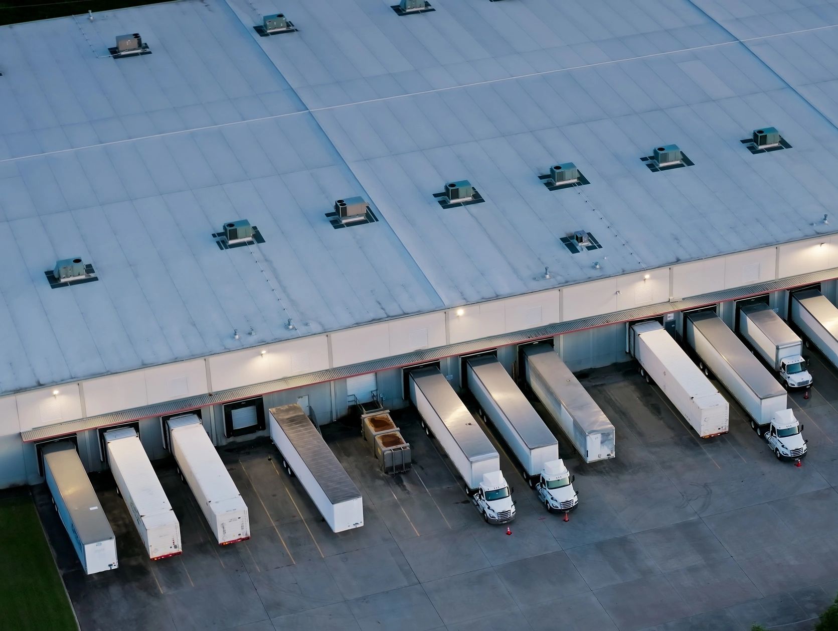 Aerial view of trucks docked at a warehouse loading area.