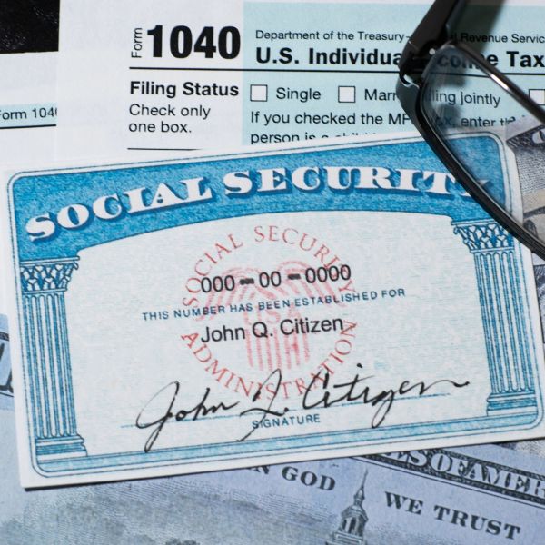 Social Security card, tax form, and money with glasses on top.