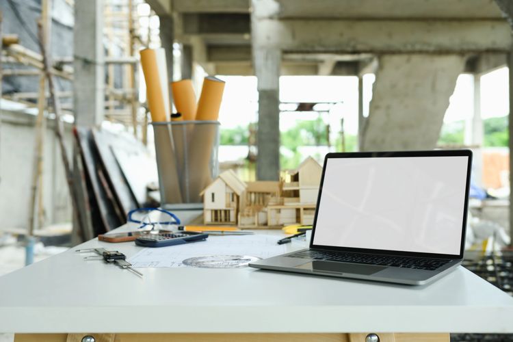 Stack of books next to pencils in a holder and a camera.