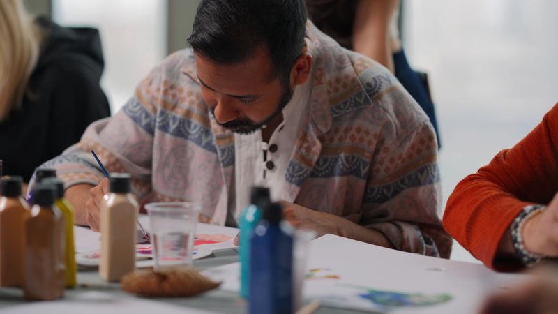 A group of multi-racial people with different ages are joining an art painting therapy session class.