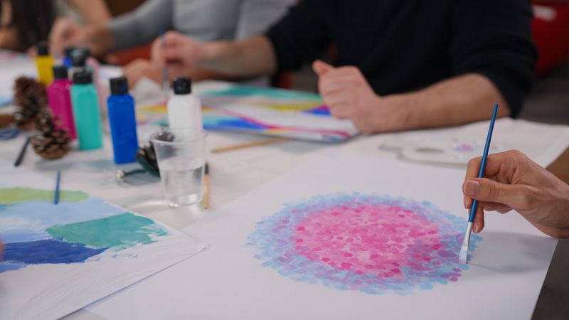 A group of multi-racial people with different ages are joining an art painting therapy session class.