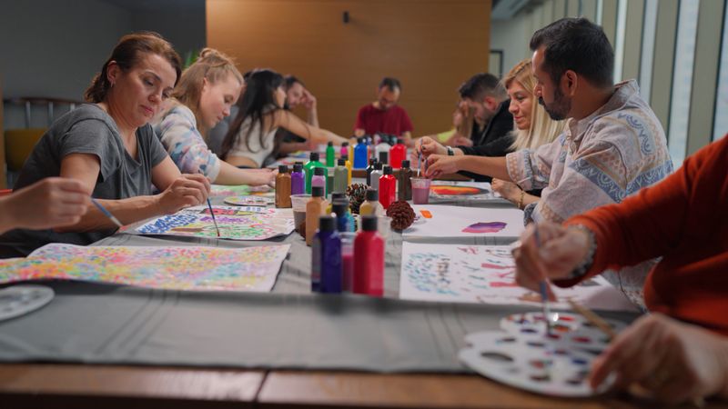 A group of multi-racial people with different ages are joining an art painting therapy session class.