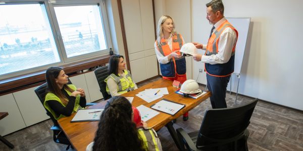 Construction meeting with safety gear discussion.