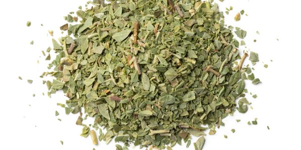 Pile of dried green herbs on a white background.
