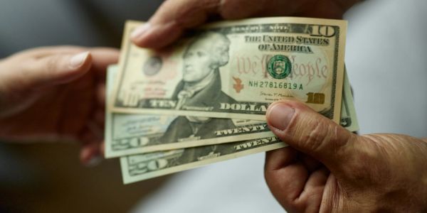 Exchange of US dollar bills between two people.