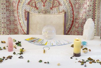 A mystical tarot reading setup with crystals, a candle, and a crystal ball.