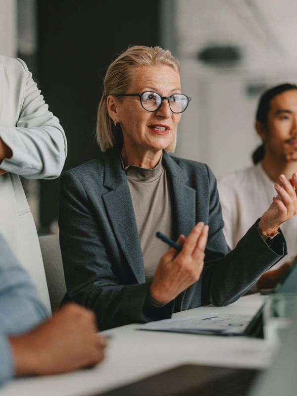 A businesswoman speaks during a meeting with colleagues.
