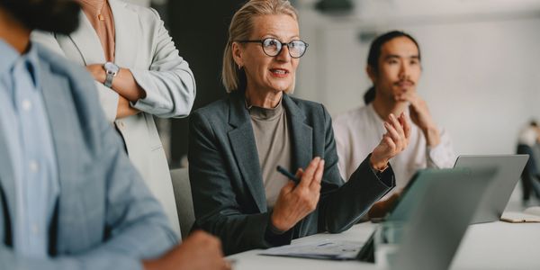 A businesswoman speaks during a meeting with colleagues.
