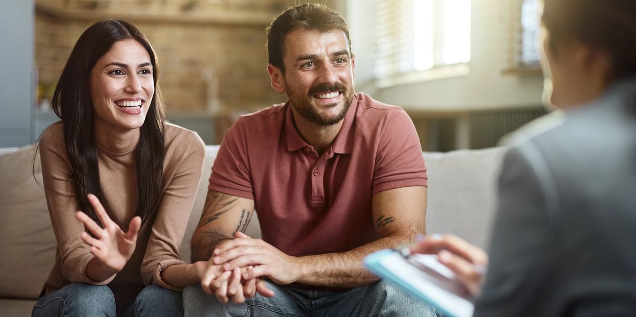 Young couple smiling during a conversation with a professional.