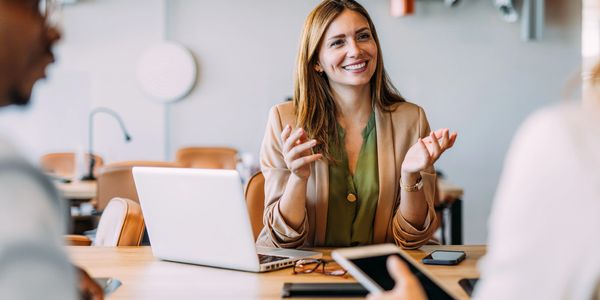 Smiling businesswoman engaging in a lively discussion during a meeting.