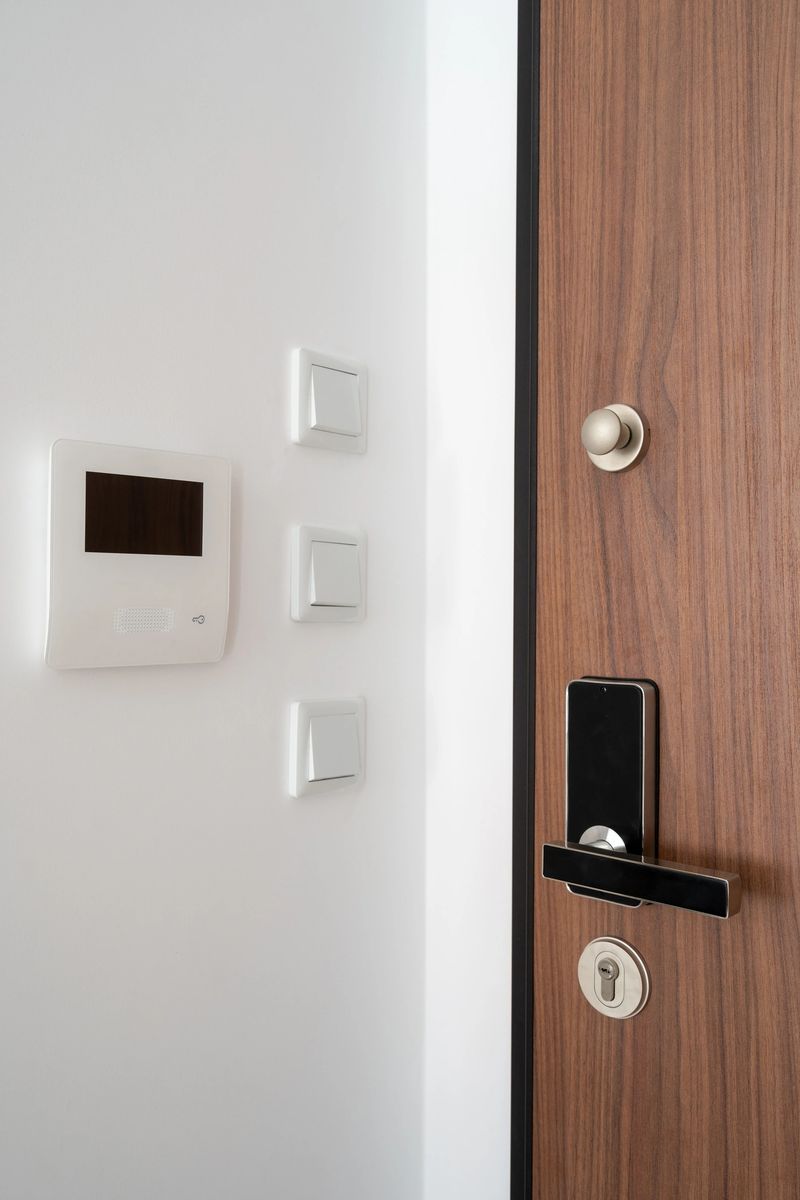 A wooden entrance door with a digital lock and an modern intercom system. Concept of smart home, automation and surveillance equipment, vertical shot