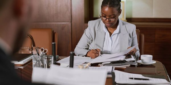 Professional woman reviewing documents in an office meeting.