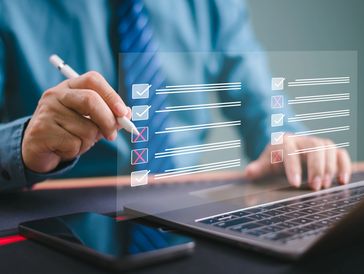 Businessman managing a digital checklist on a transparent screen.