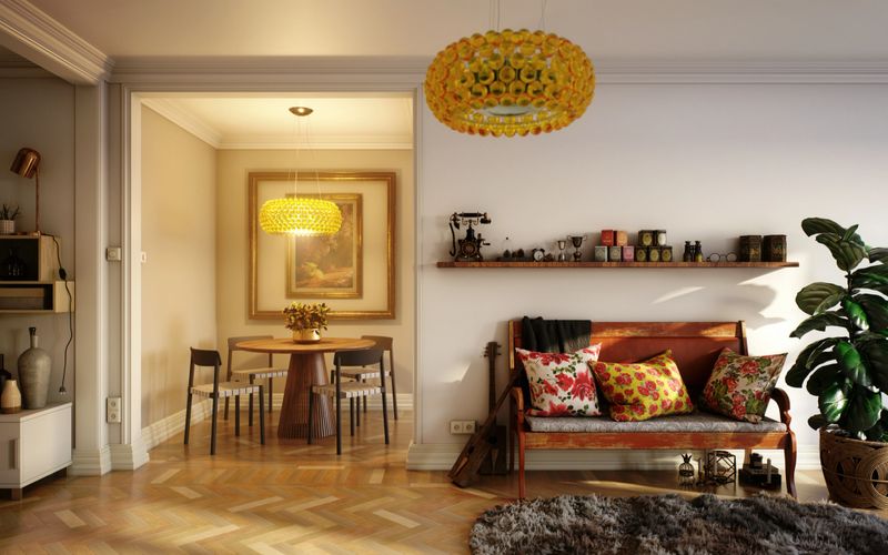 Digitally generated mid-century modern living room featuring a cozy seating area adorned with vibrant floral pillows and a sleek wooden bench. The adjoining dining area, illuminated by striking golden light fixtures, creates a warm and inviting atmosphere. Vintage décor items, lush green plants, and textured accessories add character and charm, making this space a perfect blend of comfort and style.

The scene was created in Autodesk® 3ds Max 2025 with V-Ray 6 and rendered with photorealistic shaders and lighting in Chaos® Vantage with some post-production added.
