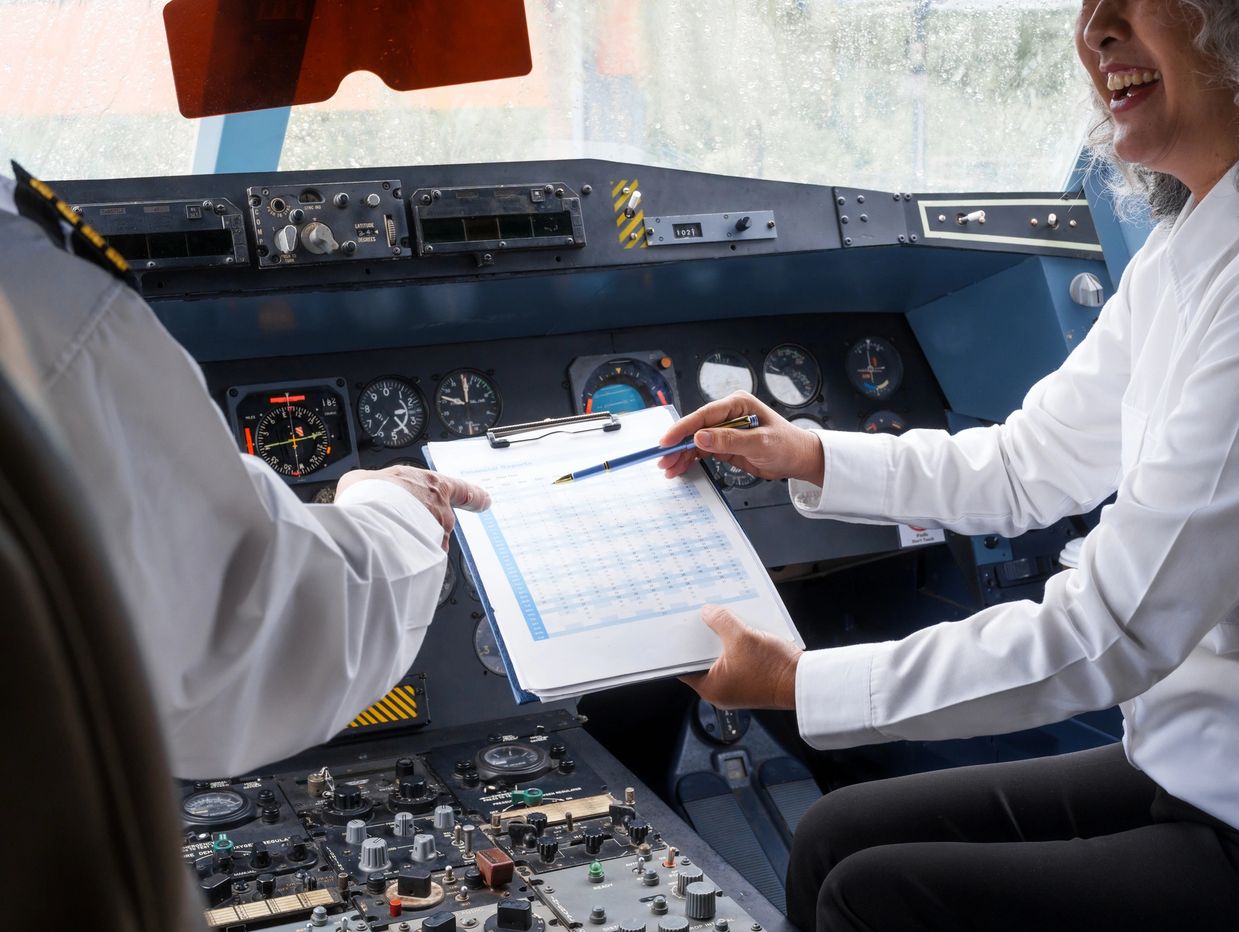 Two pilots reviewing flight data inside an aircraft cockpit.