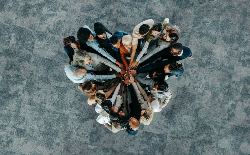 A diverse business group standing in a heart formation, symbolizing unity, teamwork, and collaboration.