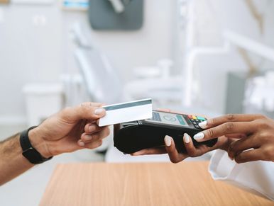 Person making contactless payment with credit card at a terminal.