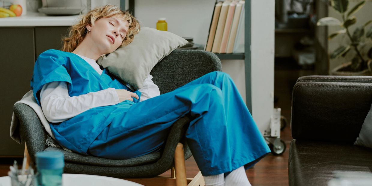 Exhausted caregiver sleeping while taking a break from caring for a family member at home.