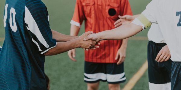 Two soccer players shake hands before the game.