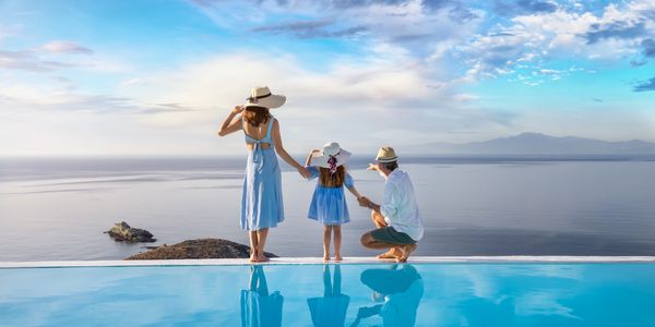 Family enjoying a scenic ocean view by the poolside at sunrise.