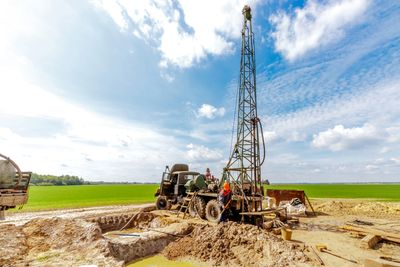 Truck-mounted drill rig advancing a borehole in open country
