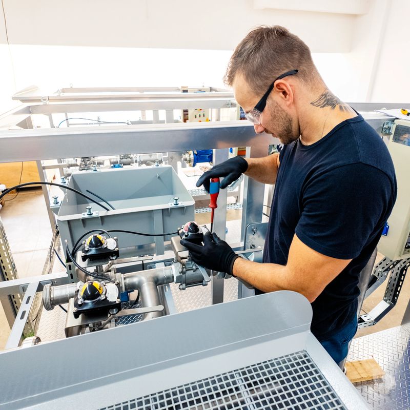 Photo of a man assembling a machine.