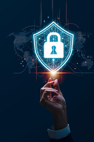 Hand holding a glowing shield with a lock symbol representing cybersecurity.