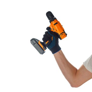 Hand holding an orange cordless power drill with a black and blue glove.