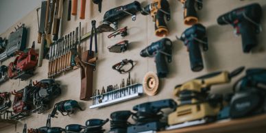 Wall-mounted display of various hand and power tools.